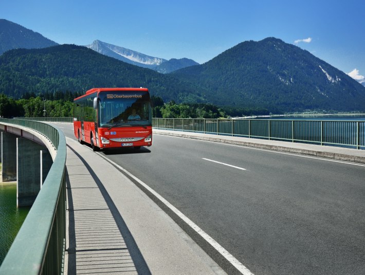 Der RVO-Bus auf der Sylvensteinbrücke mit dem fjordartigen Sylvensteinsee und Bergpanorama - nachhaltig reisen mit dem Bus, © DB Regio Bus Region Bayern