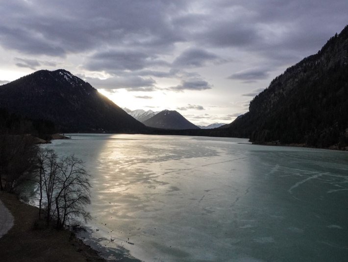 Das Bild zeigt eine mystische Stimmung des Sylvensteinsees im Winter - scherenschnittartig ragen die Berge links und rechts des Sees auf., © Landratsamt Bad Tölz-Wolfratshausen|Foto: A. Fischer