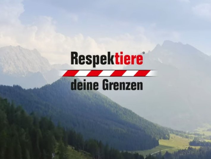 Schriftzug &quot;Respektiere Deine Grenzen&quot; mit rot-weiß-gebändertem Balken auf einem Foto einer Berglandschaft., © Bayerisches Staatsministerium für Ernährung, Landwirtschaft, Forsten und Tourismus