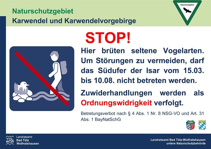 Das rechteckige Schild mit wei&szlig;em Hintergrund und dem Logo des Landratsamts Bad T&ouml;lz-Wolfratshausen hat als &Uuml;berschrift: &bdquo;Naturschutzgebiet Karwendel und Karwendelvorgebirge&ldquo;. Darunter gro&szlig;es rotes &bdquo;STOP!&ldquo;. Text: Hinweis auf br&uuml;tende seltene Vogelarten und Betretungsverbot des S&uuml;dufers der Isar vom 15. M&auml;rz bis 10. August. Hinweis auf Ordnungswidrigkeit bei Versto&szlig;. , &copy; Landratsamt Bad T&ouml;lz-Wolfratshausen