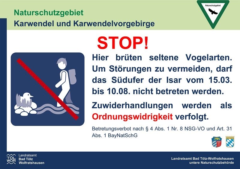 Das rechteckige Schild mit weißem Hintergrund und dem Logo des Landratsamts Bad Tölz-Wolfratshausen hat als Überschrift: „Naturschutzgebiet Karwendel und Karwendelvorgebirge“. Darunter großes rotes „STOP!“. Text: Hinweis auf brütende seltene Vogelarten und Betretungsverbot des Südufers der Isar vom 15. März bis 10. August. Hinweis auf Ordnungswidrigkeit bei Verstoß. , © Landratsamt Bad Tölz-Wolfratshausen